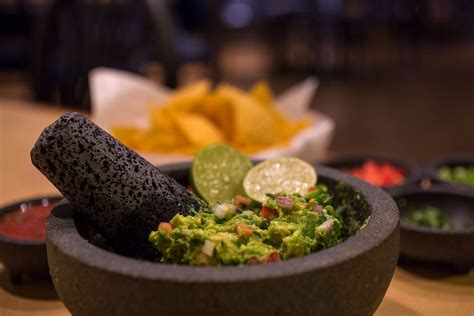 Guacamole restaurant - Instructions. Hold an avocado half in the palm of your hand and, using a butter knife, cut a grid into the flesh. Use a spoon to scoop the flesh into a mixing bowl. Repeat with the remaining avocado halves. Add the lime juice, salt, cumin, scallions, garlic (if …